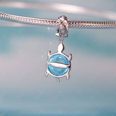 This is charm only, bracelet is sold separately.Passionately designed with a beautiful sea turtle motif, this charm is a perfect addition to any bracelet. Made of 925 sterling silver and adorned with transparent blue glass, it's a must-have for any jewelry collection. Add it to your bracelet or gift it to a loved one, and let this adorable sea turtle charm bring joy and beauty to your life. Bring a touch of elegance and wonder to your jewelry collection with this charming sea turtle pendant. Cra Sterling Silver Jewelry With Removable Round Charms, Sterling Silver Round Charms With Removable Feature, Turtle Pandora Charm, Turtle Shaped Sterling Silver Jewelry Gift, Silver Sterling Silver Turtle Jewelry, Sterling Silver Turtle Jewelry Gift, Silver Turtle Jewelry Gift, Elegant Silver Turtle Jewelry, Sea Turtle Pendant