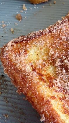 two pieces of french toast sitting on top of a metal pan covered in powdered sugar