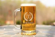 a beer mug sitting on top of a table with the word thomas printed on it