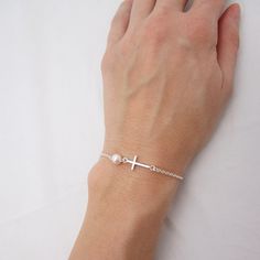 SOLID STERLING SILVER PARTS - A QUALITY BRACELET This lovingly hand-made bracelet is crafted using a solid sterling silver cross that measures just under 3/4 inch long. A 6mm Swarovski pearl comes in your choice of 5 colors. The sturdy sterling silver chain and lobster clasp make this a durable bracelet. Comes in a gift box. SIZING - IMPORTANT: To determine bracelet size, measure snugly around your wrist and add 1/2 inch to get your bracelet size. Do NOT order in your exact wrist measurement. Silver Cross Bracelets For Gifts, Minimalist Sterling Silver Cross Bracelet, Dainty Sterling Silver Cross Bracelet, Nickel Free Silver Cross Bracelets, Nickel Free Sterling Silver Cross Bracelets, Silver Bracelet With Cross Pendant As Gift, Silver Cross Bracelet, Spiritual Style, Nickel-free Cross Bracelet Gift, Nickel-free Silver Cross Bracelets