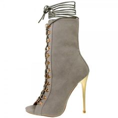 a pair of high heeled shoes with laces on the side and gold toe