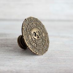 a button with a skull on it sitting on a table