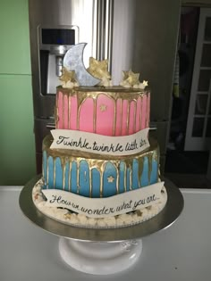 a three tiered cake decorated with gold and pink icing