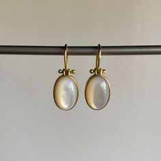 Mother of pearl shimmers sweetly at the end of buttery gold ear wires in this dreamy pair. 18k yellow gold Mother of pearl, 8.08ctw, 8mm x 11mm (5/16" x 1/2") Earrings hang 7/8" from the ear Each earring weighs 2g Cabochon Earrings, Mother Of Pearl Earrings, 2 Earrings, Newport Ri, Aesthetic Themes, Bracelet Gift, Ring Necklace, Ear Wires, Newport