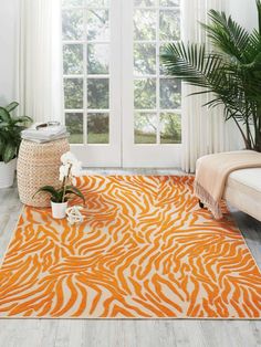 an orange and white rug with zebra print on the floor in front of a window