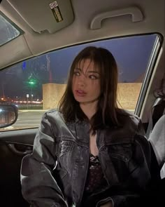 a woman sitting in the back seat of a car