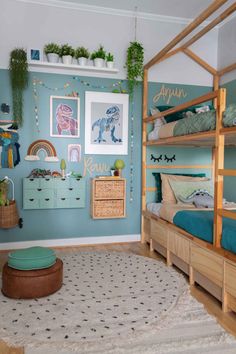 a child's bedroom with blue walls and wooden bunk beds, green rugs and pictures on the wall