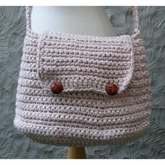 a crocheted purse sitting on top of a white mannequin