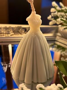 a close up of a dress on a mannequin with flowers in the background