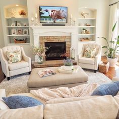 a living room with couches, chairs and a fire place in the middle of it