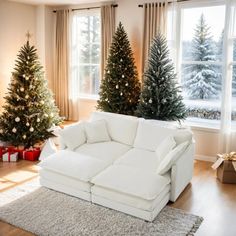 a living room decorated for christmas with white couches and small trees in the corner