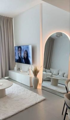 a living room filled with furniture and a flat screen tv on top of a white table