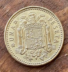 an old gold coin sitting on top of a wooden table