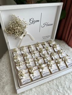 a white box filled with lots of small boxes covered in baby's breath flowers