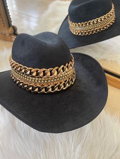 Our love of hats just got became a full-on obsession: meet the Beth Dutton Chain Banded cowboy hat! The most chic, high-end hat we could've ever dreamed up. A hat this good needs to be worn as much as possible and with every single outfit! Hand made by artisans, incredible quality, pure suede, hand placed chain around the crown, too many details to list! The best part? It's super structured with an elastic band on the inside that will fit EVERYONE. Btw never taking this hat off. These hats are a Elegant Flat Brim Fedora For Western-themed Events, Elegant Fedora For Western-themed Events, Gold Fedora Hat For Rodeo, Luxury Adjustable Hat Bands For Rodeo, Gold Flat Brim Hat Bands For Kentucky Derby, Western Gold Hat Bands For Party, Western Style Gold Hat Bands For Parties, Luxury Flat Brim Hat For Rodeo, Gold Fedora Western Hat