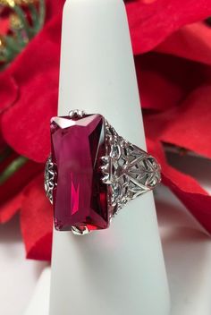 Simulated Ruby Ring Description Intaglio Design#31 MADE TO ORDER Inspired by the intricate Victorian designs of the late 1800s, I now offer this gorgeous filigree Antique reproduction in sterling silver. The lovely ring is set with a flawless 7ct simulated red ruby. The baguette rectangle-cut red ruby color gem is 18mm long by 9mm wide. The ring is 8mm off the finger. The inside of the band is marked 925 for sterling. Notice the intricate and detailed design of the silver filigree setting and ba Classic Formal Burgundy Rings, Classic Ruby Ring With Diamond Cut, Classic Burgundy Ruby Ring For Formal Occasions, Classic Red Ruby Jewelry, Formal Ruby Ring With Prong Setting For Valentine's Day, Classic Lab-created Ruby Ring With Diamond Cut, Formal Lab-created Ruby Ring With Diamond Cut, Elegant Red Emerald-cut Jewelry, Classic Burgundy Ruby Ring