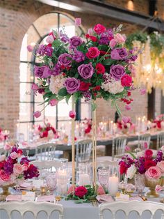 a tall centerpiece with pink and purple flowers