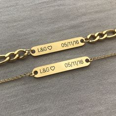 two personalized gold chain bracelets with names engraved on the side and heart charms attached to them