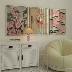 two paintings hang on the wall next to a white cabinet with drawers and a lamp