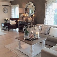 a living room filled with lots of furniture and candles on top of a coffee table