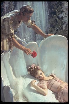 a woman is touching the back of a child's body in a bathtub