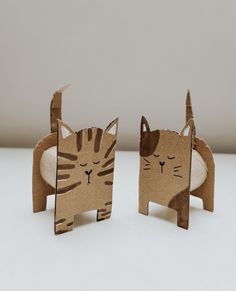 two cardboard cats sitting next to each other