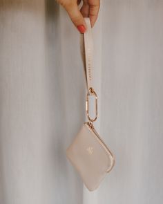 a person holding onto a white purse with a keychain hanging from the handle