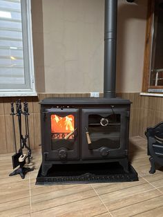 a wood burning stove in a room with tile flooring