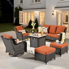 an outdoor living room with orange furniture and white tile flooring outside at night time