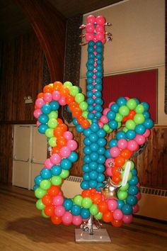 a balloon sculpture in the middle of a room with wood flooring and wooden walls