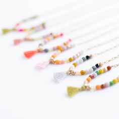 This beautiful necklace is guaranteed to turn heads! Delicate and dainty, its 16" of tiny 3mm czech glass beads are expertly woven to an antique gold plated chain and finished with an oh-so-fashionable tassel at its center. Elegant, eye-catching, and utterly unique—this necklace is the perfect finishing touch to any outfit! Choose from 5 colors: Coral Tassel: Red, mustard, pink, coral, aqua, grey, and gold beads Moss green Tassel: brown, gold, chartreuse, green, lilac, brown, pumpkin, moss, gold Indie Craft, Pink Tassel, Spring 2023, Travel Jewelry, Beautiful Necklace, Moss Green, Gold Plated Chains, Pop Up Shop, Amethyst Crystal