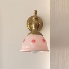 a pink light hanging from the side of a white wall