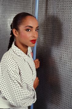 a woman standing in front of a metal wall