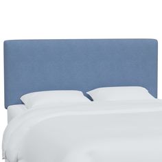 a blue headboard with white sheets and pillows