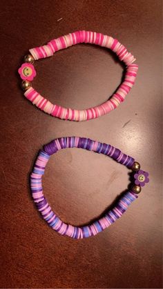 two pink and purple bracelets sitting on top of a table