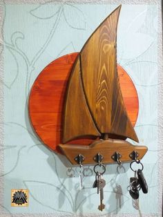 a wooden sailboat mounted on a wall with keys