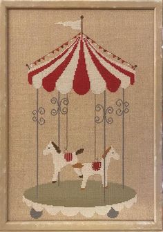 a cross stitch picture with a white horse and a red and white striped circus tent