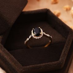 a black diamond ring sitting in a box