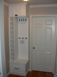 a white coat rack in the corner of a room next to a door and closet