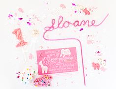 some confetti and pink items on a white surface with the word lolane