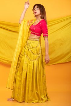 Canary yellow kalidar lehenga with intricate handwork floral buttis and side tassels. Comes with contrast pink blouse with floral buttis and tassels and a semi-sheer yellow dupatta.
Components: 3
Pattern: Embroidered
Type Of Work: Floral Buttis
Neckline: Scoop
Sleeve Type: Elbow
Fabric: Silk Blend
Color: Yellow
Other Details: 
Lehenga:
Floral buttis
Side tassels
Attached lining
Length: 43 inches
Closure: Side zip
Blouse:
Back cutout
Back straps
Tassels
Closure: Back hooks
Dupatta:
Semi-sheer
Linear patterns
Product weight (in kgs): 1.5
Occasion: Mehendi and Haldi - Aza Fashions Yellow Semi-stitched Sets For Navratri, Bollywood Style Pre-draped Saree With Tilla For Navratri, Festive Yellow Fitted Pre-draped Saree, Semi-stitched Tilla Sharara For Festivals, Bollywood Style Tilla Choli For Eid, Yellow Raw Silk Choli With Dupatta, Diwali Lehenga With Tilla And Kundan, Yellow Pre-draped Saree With Resham Embroidery, Kundan Lehenga With Tilla For Navratri