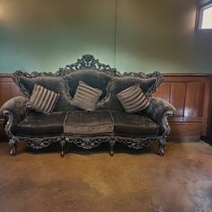 a couch with two pillows on top of it in a room that has wood paneling