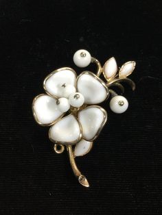 Gorgeous Trifari brooch all done on brilliant gold plated metal.  Large five molded glass petals all bezel set white milkglass with three white milkglass beaded stamen in center.  Three buff top milkglass navette leaves and two white milkglass beaded flower buds.  Measuring 2 3/8" by 1 1/4".  GORGEOUS! Antique White Brooches For Wedding, Victorian White Brooch For Anniversary, Antique White Brooch For Formal Occasions, Antique White Formal Brooch, Vintage White Wedding Brooches, White Vintage Collectible Brooch, Vintage White Flower Brooches, White Vintage Flower Brooches, Vintage White Flower Brooch