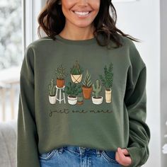 a woman wearing a green sweatshirt with potted plants on it