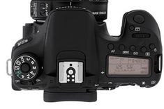 the back view of a digital camera with its lens up and control buttons on it