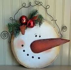 a snowman decoration with ornaments hanging on the wall