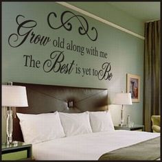 a bedroom with a large bed and wall decal on the wall that says grow old along with me, the best is yet to be