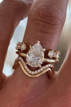 a woman's hand with two gold rings and a diamond ring on top of her finger