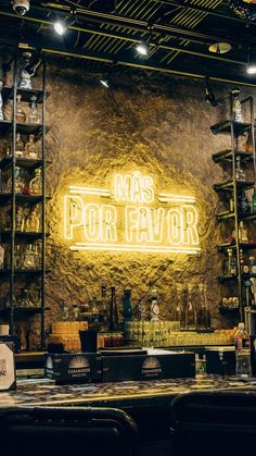 the bar is decorated with neon signs and bottles