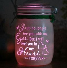 a mason jar that has some writing on it and is lit up with pink light